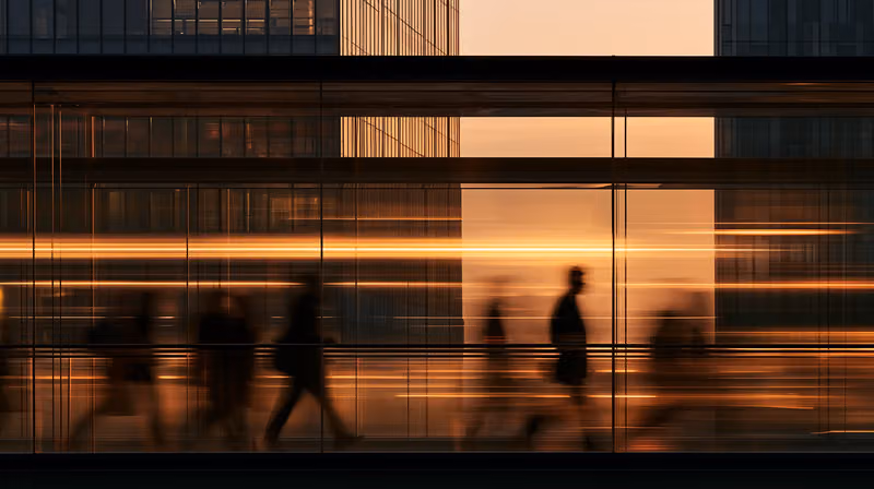 People passing a glass office façade in long exposure
